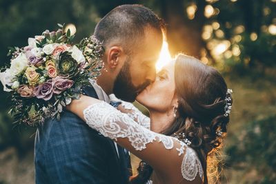 Midsection of man and woman holding flower bouquet