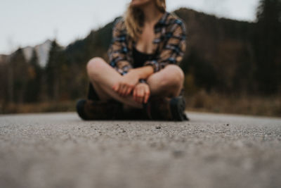 Young woman sitting on road