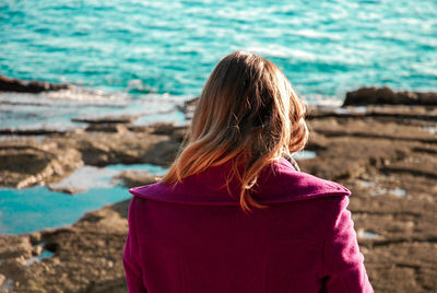 Rear view of woman standing against sea