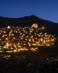 High angle view of illuminated buildings against sky at night