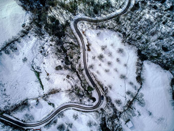 Aerial view of winding road through snowy landscape in asturias mountains in spain. winter time.