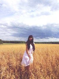 Woman standing on field against sky