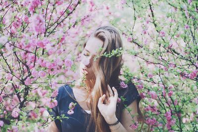 Young woman standing by flowering plants