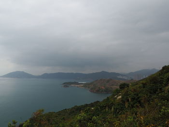 Scenic view of sea and mountains against sky