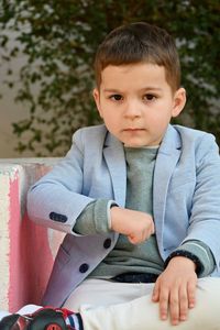 Portrait of cute boy sitting outdoors