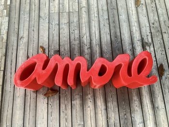 High angle view of red text on wooden plank