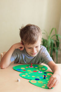 Child rolls the dice and moves the chip across the christmas playing field