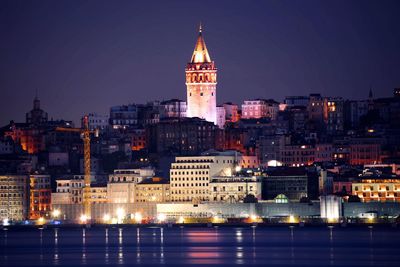 Illuminated buildings against sky at night