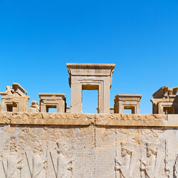 Low angle view of old building against clear blue sky