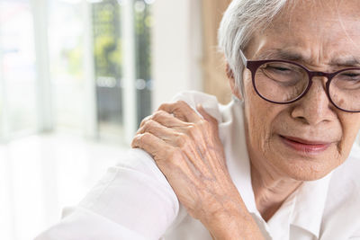 Senior woman touching shoulder