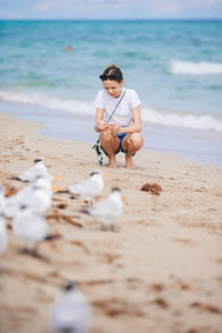 Side view of woman sitting on beach