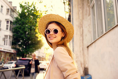 Portrait of young woman in sunglasses hat