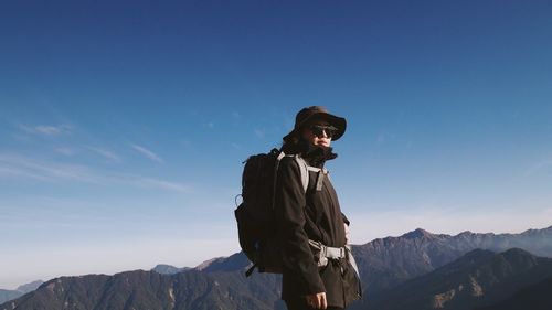 Man standing on mountain against sky