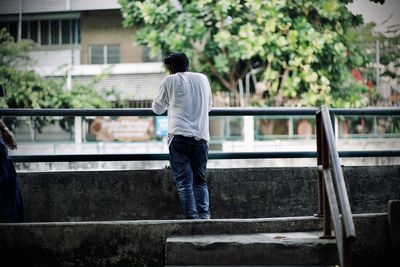 Rear view of man standing by railing