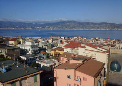 High angle view of townscape by sea against sky