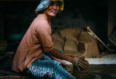 Portrait of smiling young woman sitting outdoors