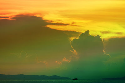 Scenic view of sea against dramatic sky during sunset