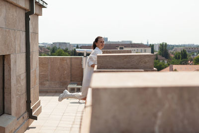 Side view of young woman sitting on steps