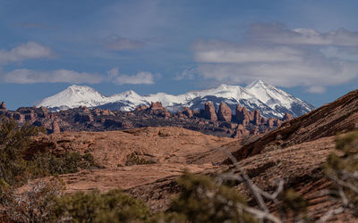 Full frame view of sandstone formations with snow capped mountains in the background