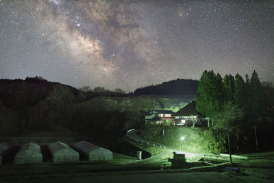 Scenic view of illuminated house against sky at night