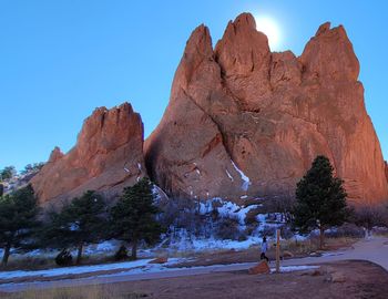 Rock formations on snow covered mountain against sky