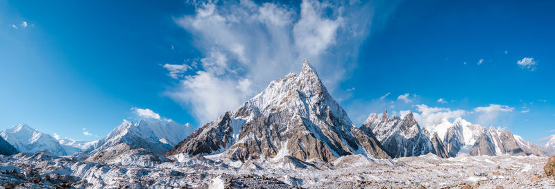 Panoramic view of snowcapped mountains against blue sky