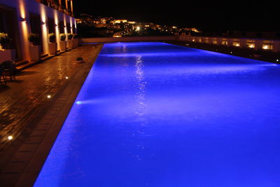 Reflection of illuminated buildings in swimming pool at night