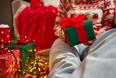 Midsection of woman holding gift on table