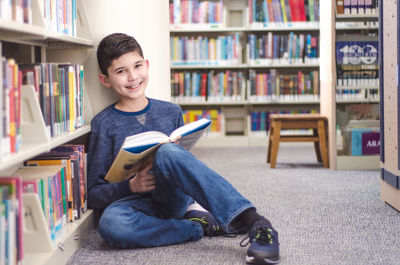 Portrait of boy sitting on book