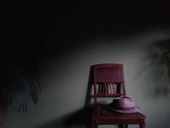 Empty chairs with hat against wall at home