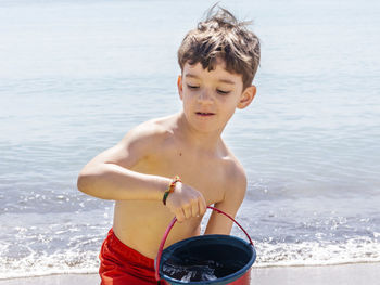 Full length of shirtless boy on beach