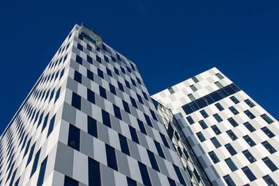 Low angle view of modern building against clear blue sky