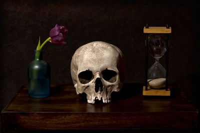 Close-up of human skull and vase on table