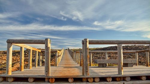 Wooden pier over sea against sky