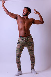 Shirtless man standing against white background