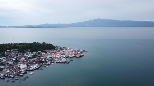 Aerial view of sea and mountains against sky