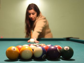 Brunette caucasian girl plays billiards