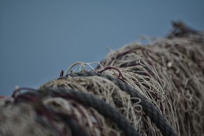 Close-up of fishing net against clear blue sky