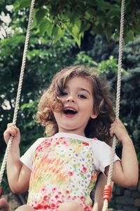 Low angle view of girl on swing at playground