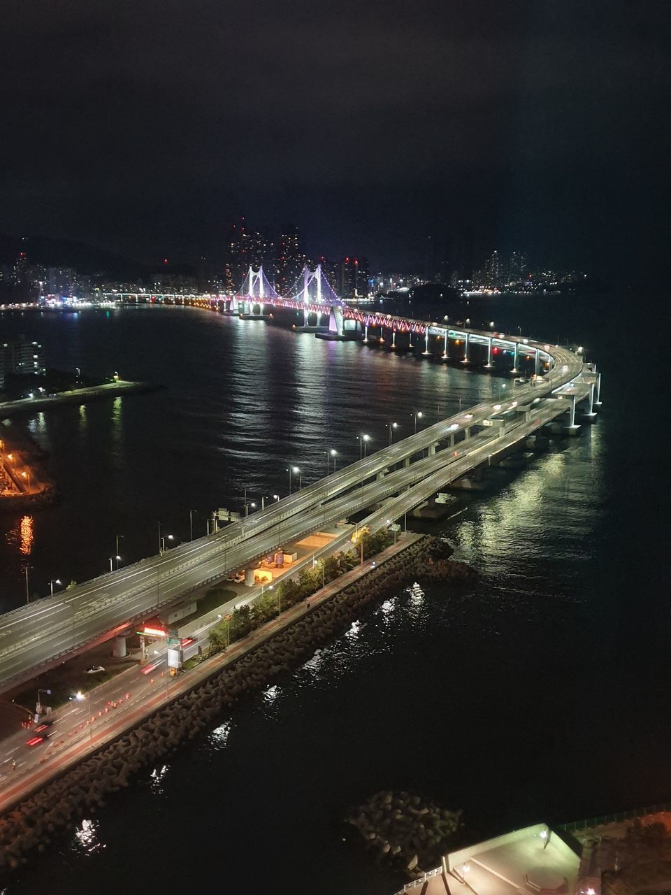 HIGH ANGLE VIEW OF ILLUMINATED BRIDGE AT NIGHT