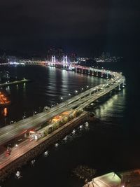High angle view of illuminated bridge over river in city at night