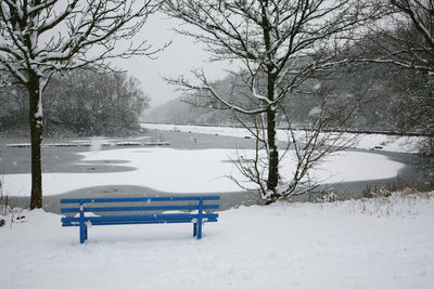 Empty benches on snow covered park during winter