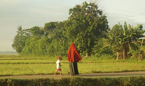 Rear view of woman standing on field