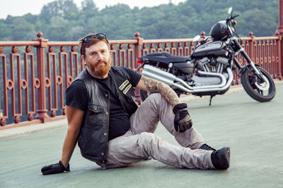 Full length portrait of young man sitting on motorcycle