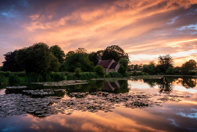 Scenic view of lake against sky at sunset