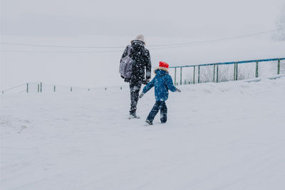 Dad and son during a blizzard in the field. travelers stuck on the road