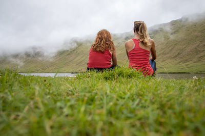 Two friends sitting in nature, landscape, caldera of corvo, azores.