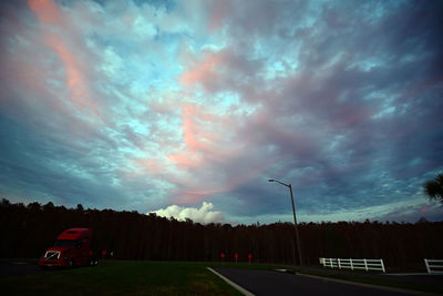 Car on road against storm clouds