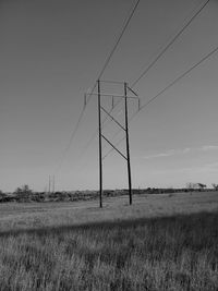 Electricity pylon on field against sky