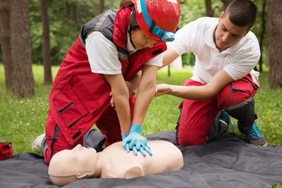 Healthcare workers practicing on cpr dummy at park